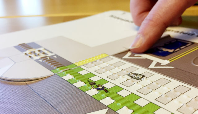 a person explores tactile image of an intersection design