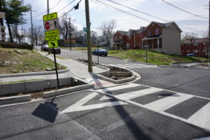 Low Impact Design stormwater retention combine with curb bulb-outs and better crosswalks to improve the drainage and pedestrian safety of a DC community