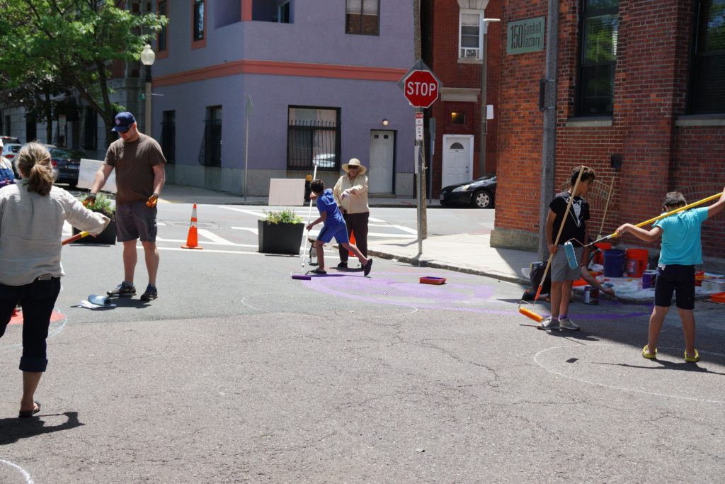 Volunteers and community members pitching in to help paint the new pocket park on Gove Street in East Boston.