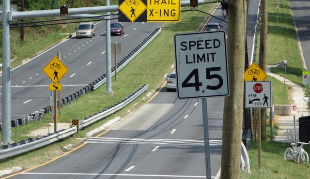 Six lane trail crossing with ghost bike in median