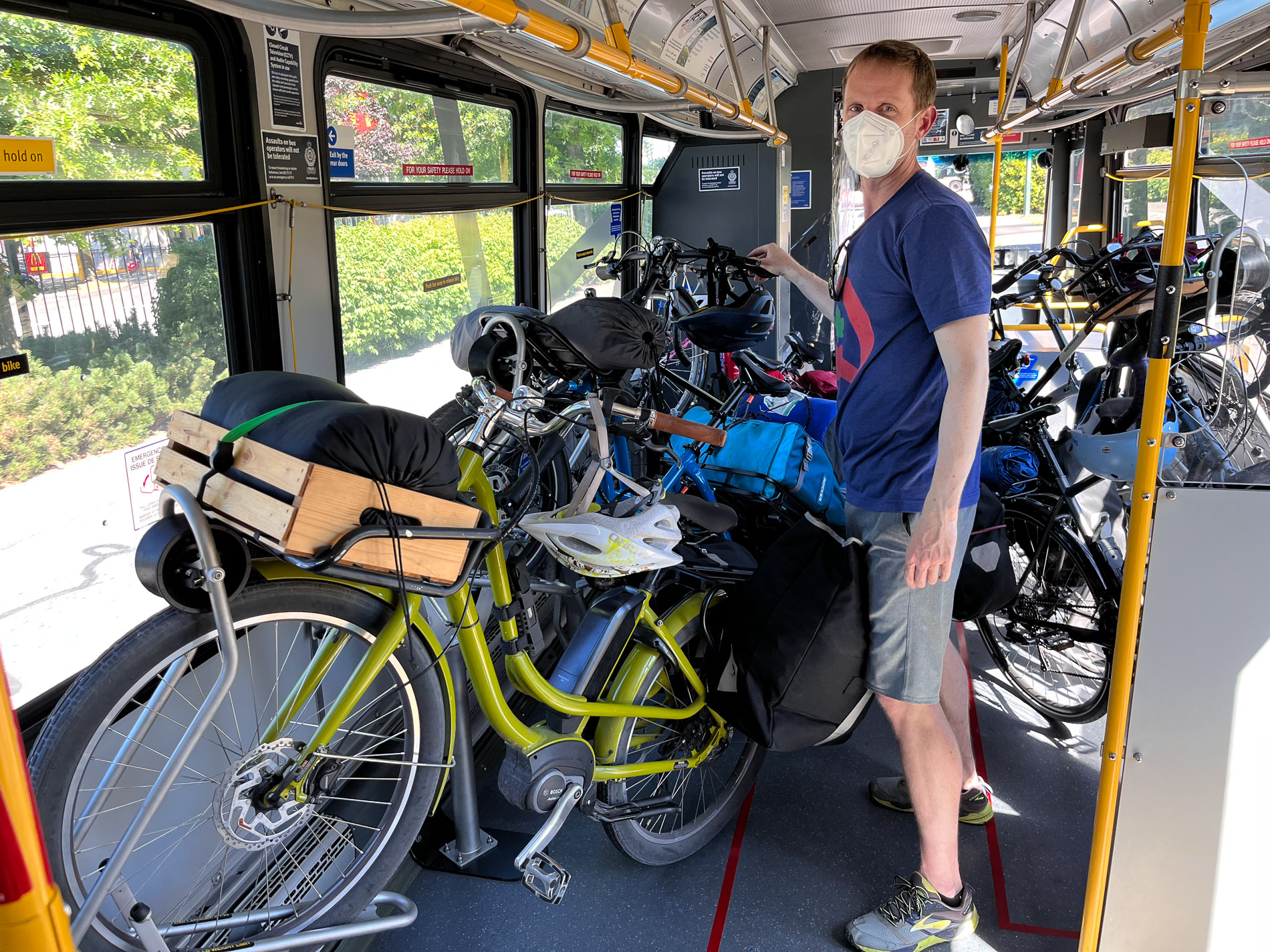 Dylan on a bus surrounded by a variety of bikes.