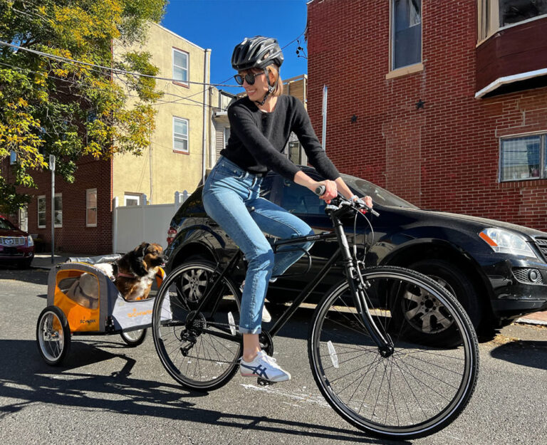 Toole Design Philadelphia Office Director Carrie Long riding her bike with two dogs in the trailer