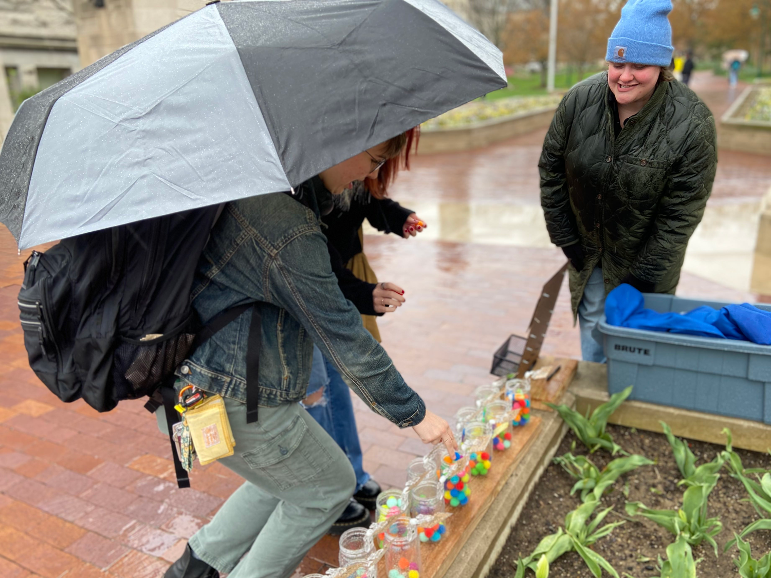 Two students respond to an pom-pom activity as part of a Safety Week engagement pop-up event outside Indiana University