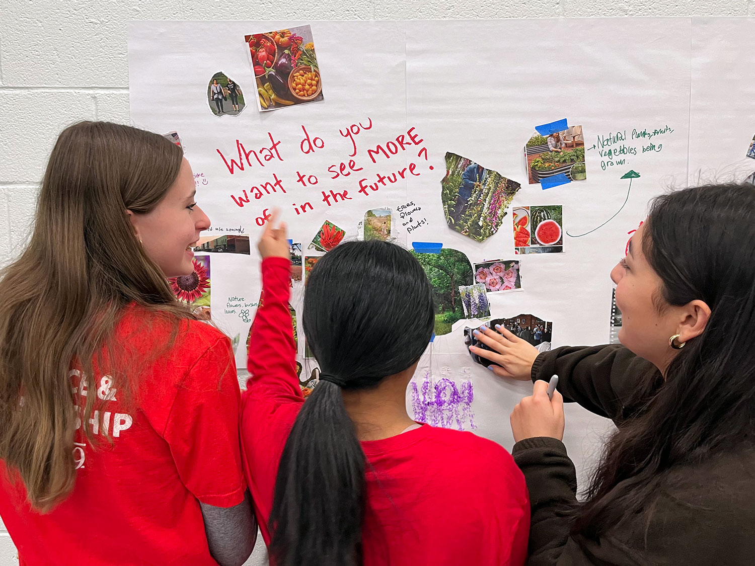 Three teenage girls from the Cary Teen Council smiling as they participate in an engagement activity for the Cary Bike Plan.